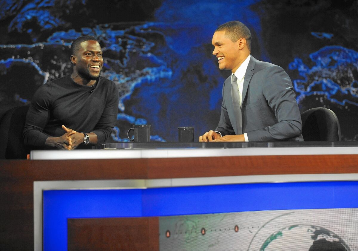Trevor Noah, in his first night as host of Comedy Central's "The Daily Show," banters with comedian Kevin Hart.