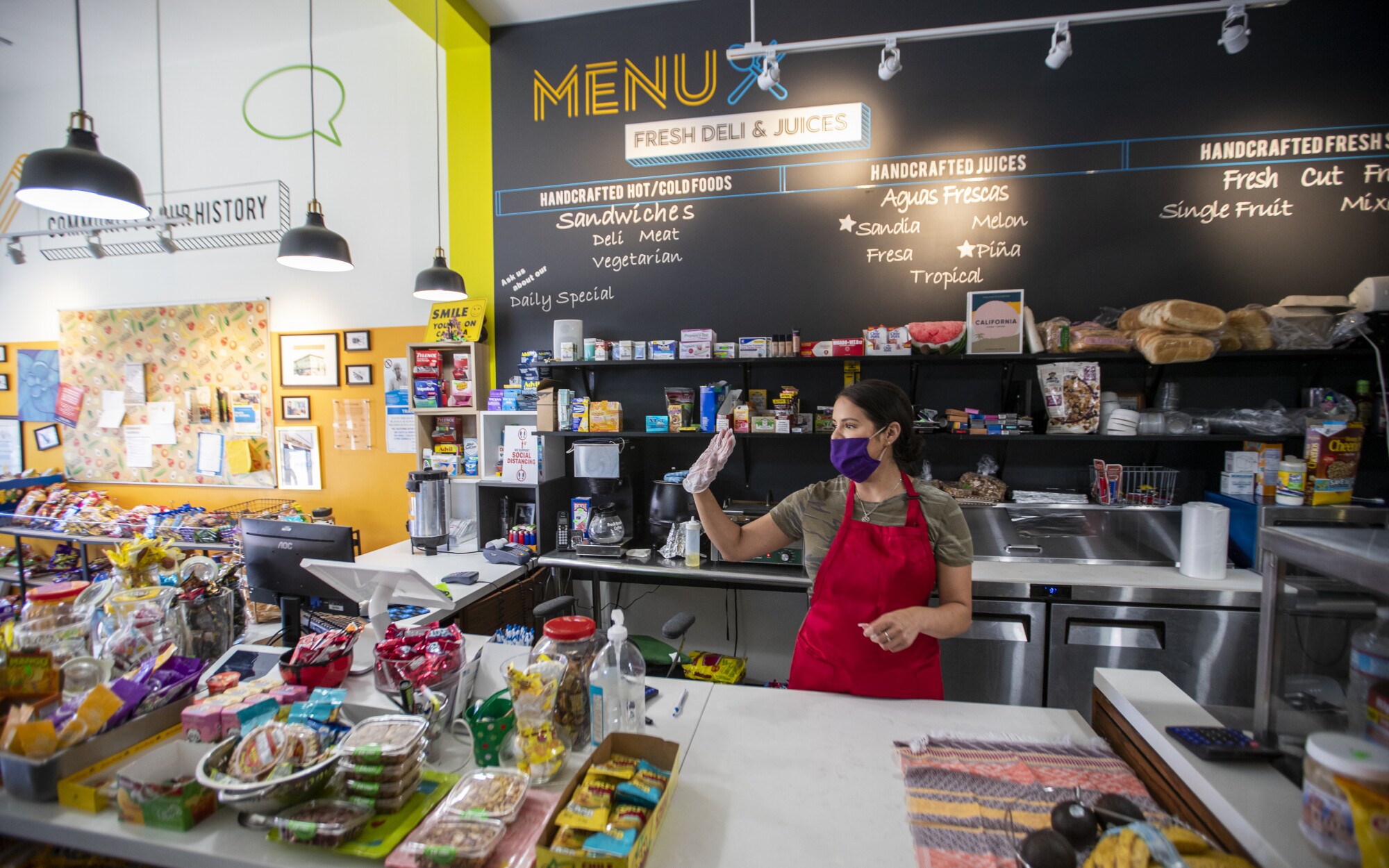 Luz Arango waves at a regular patron at Lupita's Corner Market and Deli in L.A.'s Westlake District