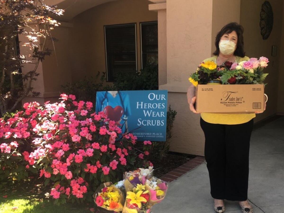 Pamela at Somerford Senior Care accepts flowers from ALRSD.