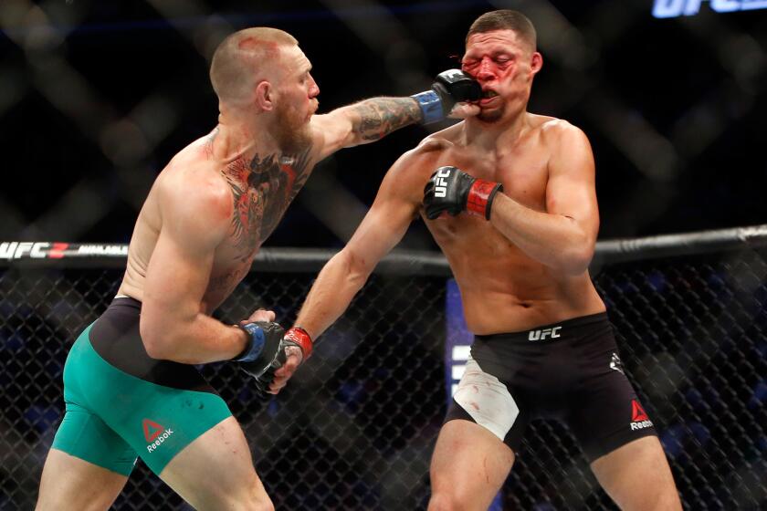 Conor McGregor lands a left to the face of Nate Diaz during their welterweight rematch at UFC 202.