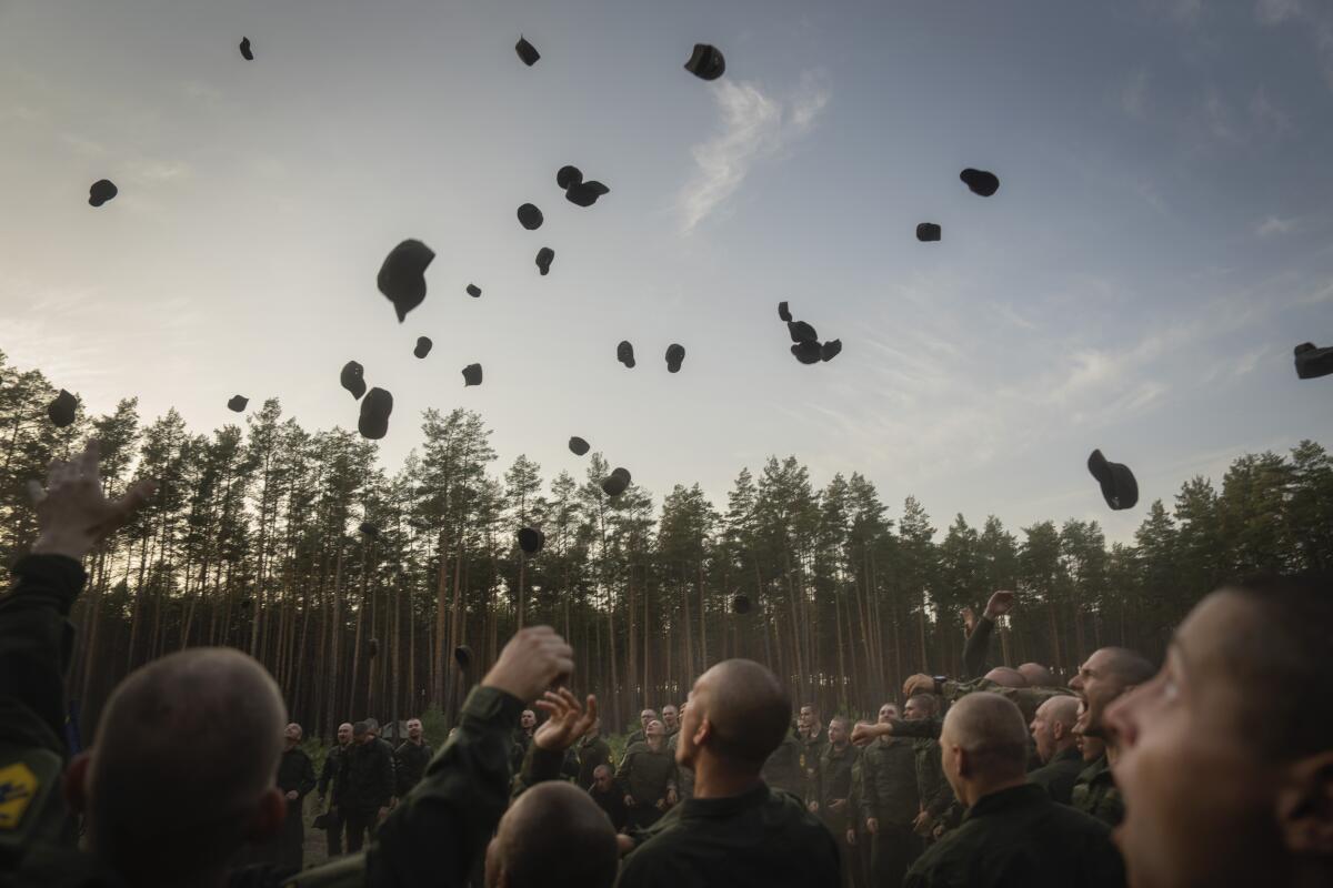 New soldiers toss their hats in the air in celebration.