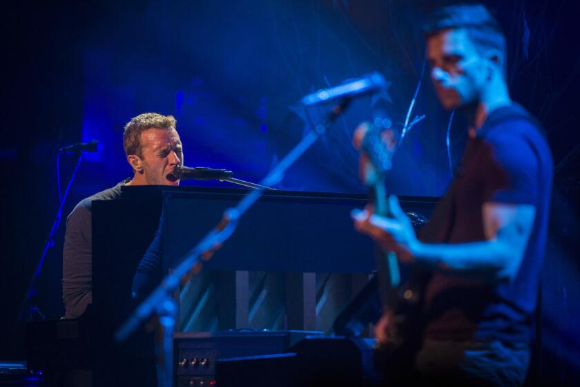 Chris Martin, left, and bassist Guy Berryman from Coldplay performing recently at the Beacon Theatre in New York. Coldplay's "Ghost Stories" is the fastest-selling album of 2014 so far.