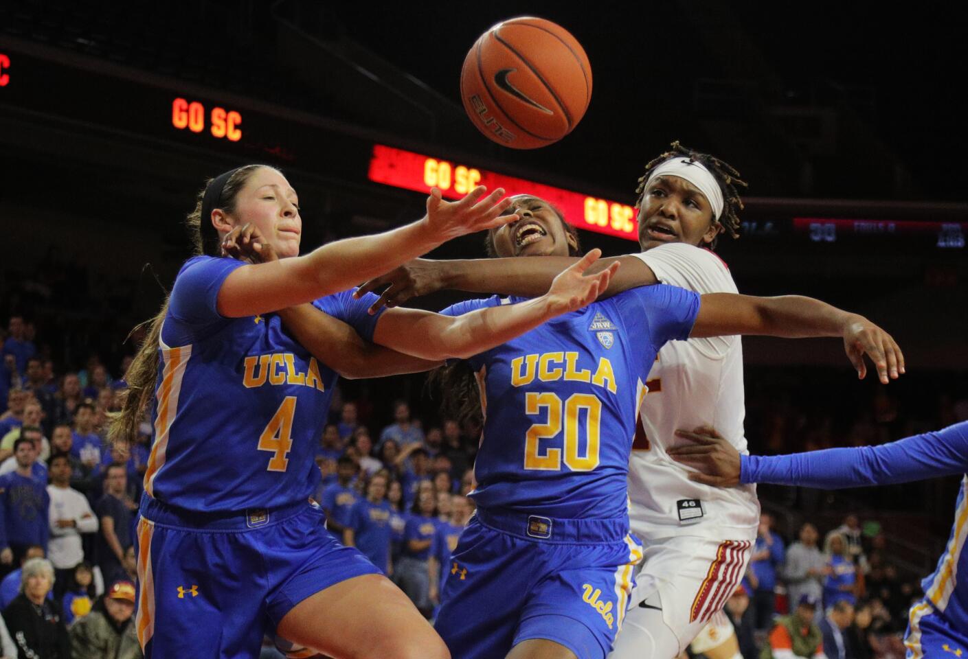 UCLA guard Charisma Osborne (20) gets hit by USC guard Aliyah Jeune (11) while battling for a rebound in overtime of a game Jan. 17 at Galen Center.