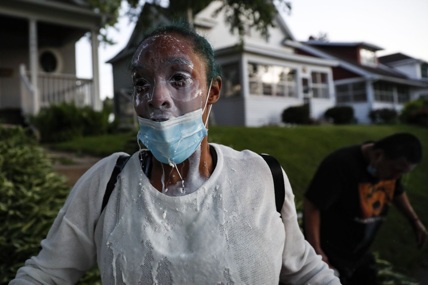 A protester douses her face with milk after being exposed to tear gas fired by police in St. Paul.