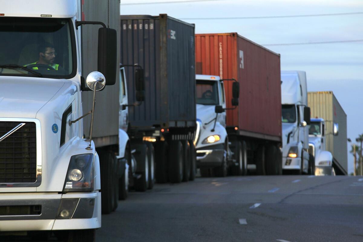 Trucks wait in line to deliver their cargo at the Port of Long Beach in April.