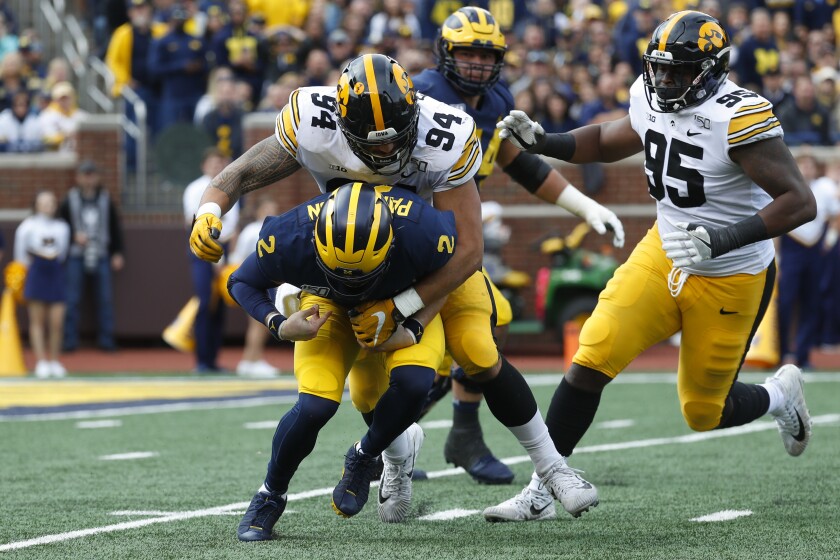 Iowa defensive end A.J. Epenesa (94) sacks Michigan quarterback Shea Patterson (2) during the first half of an NCAA college football game in Ann Arbor, Mich., Saturday, Oct. 5, 2019.