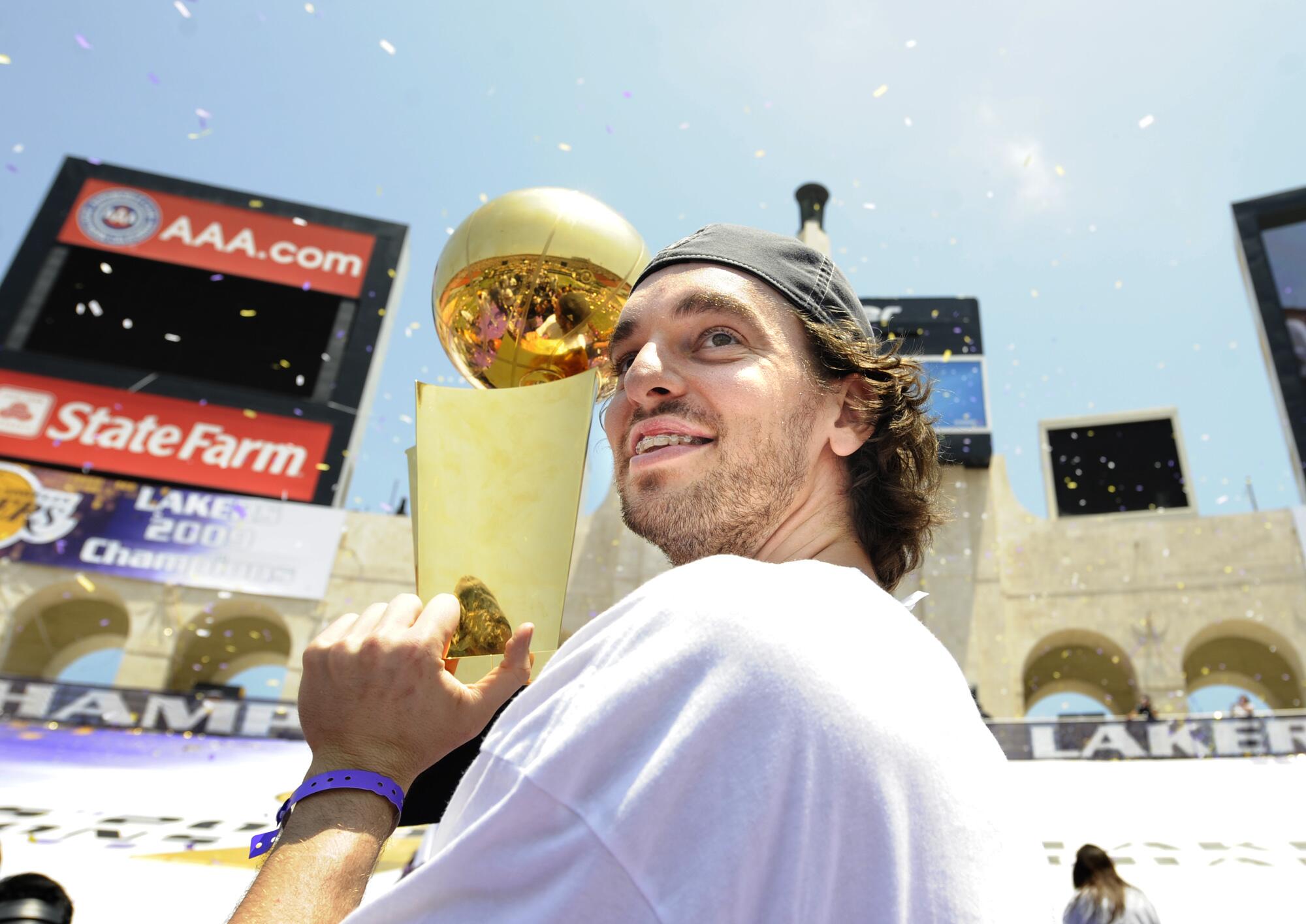 Pau Gasol carries the championship trophy up stairs at the Coliseum following the Lakers' 2009 NBA Championship celebration.