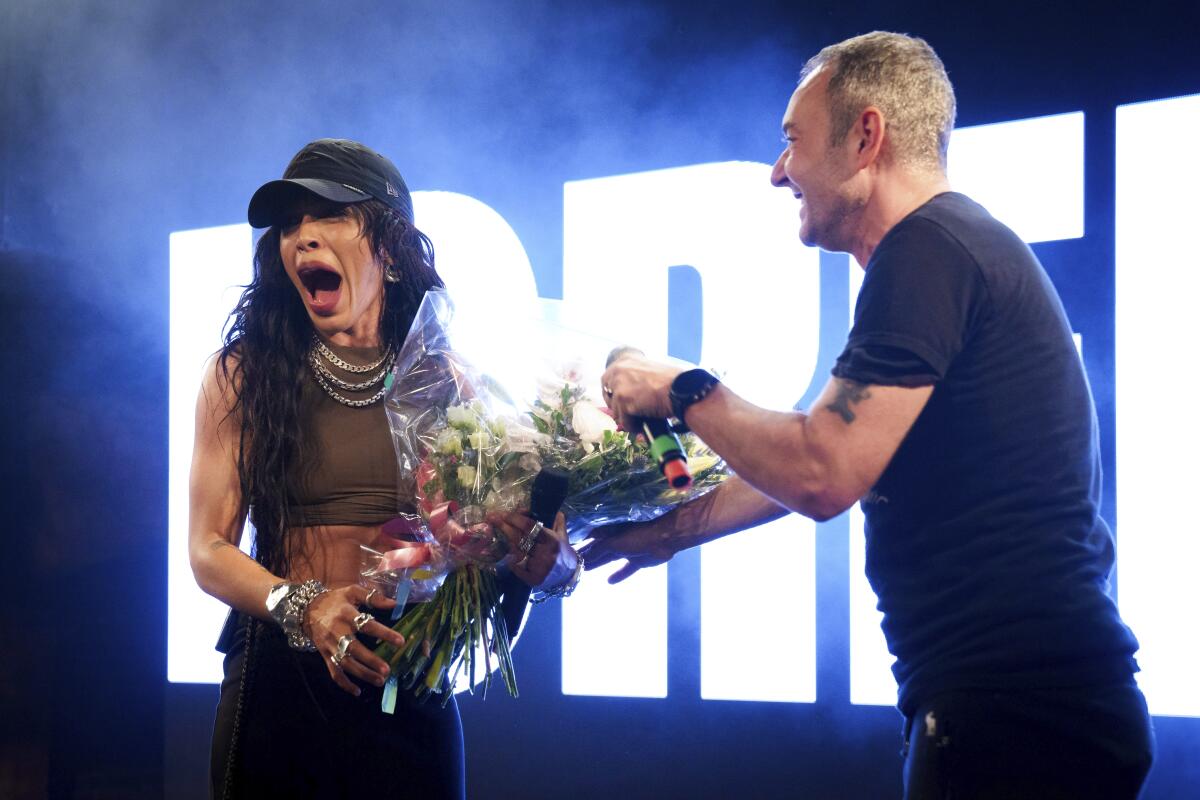 Loreen, izquierda, recibe un ramo de rosas de Jeremy Joseph en el escenario del Heaven Nightclub