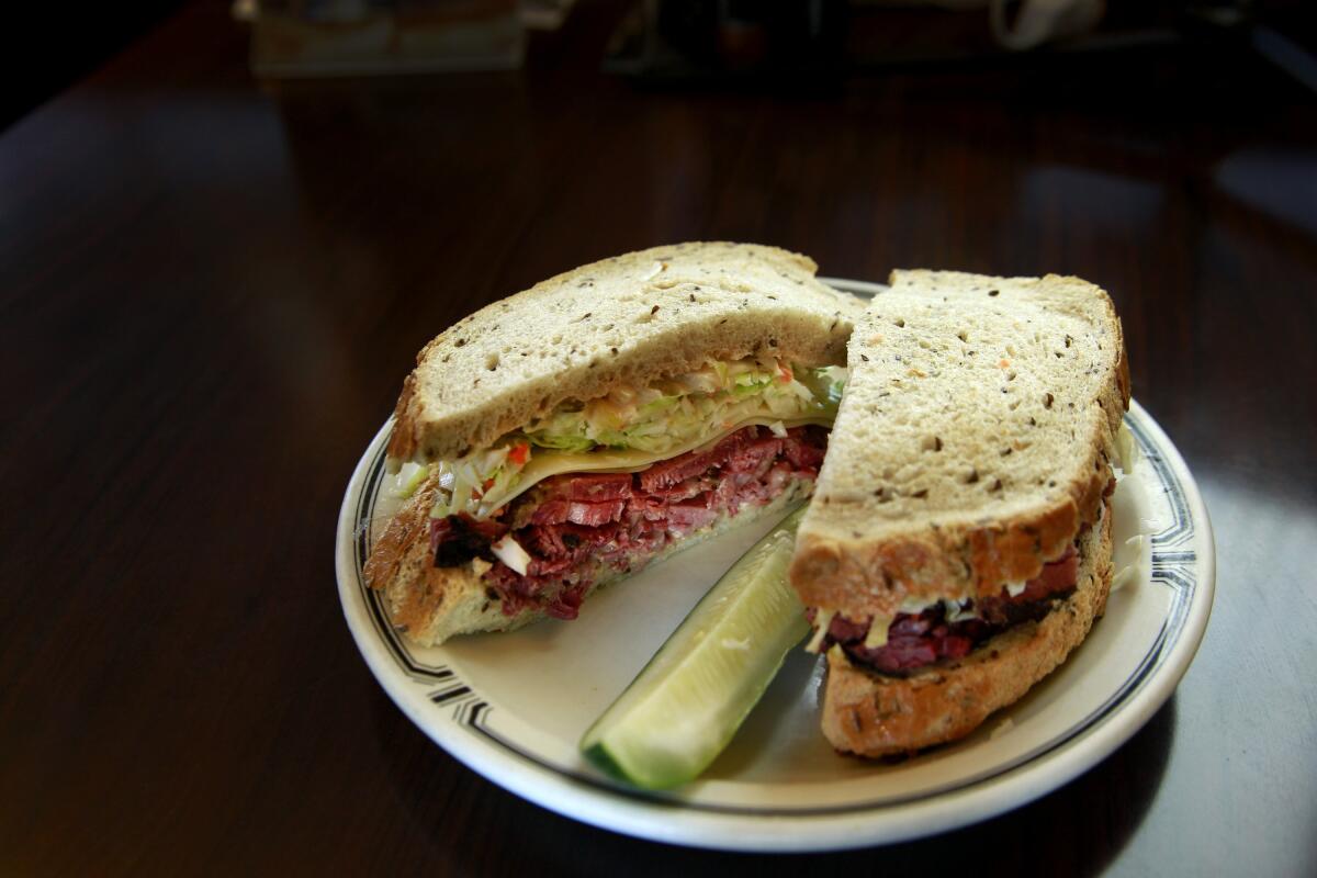 A sandwich cut in half with a pickle on a plate 