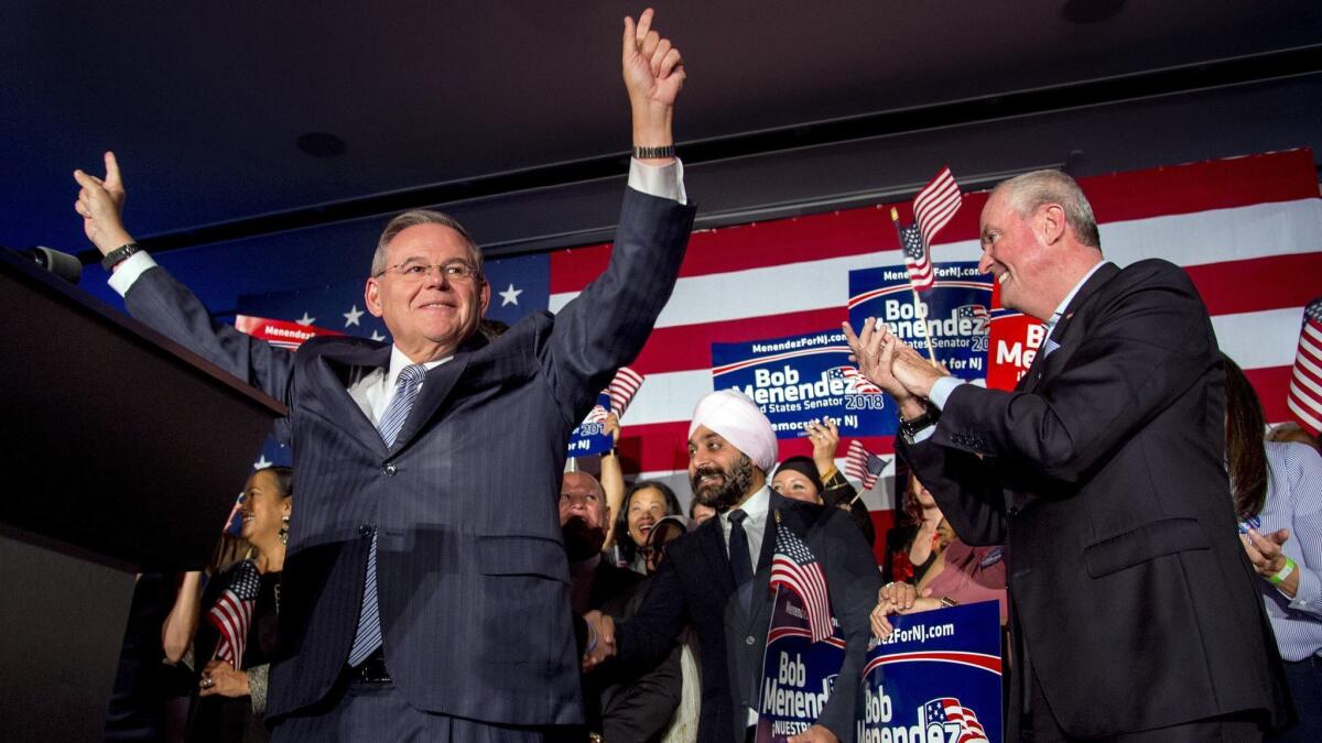 Sen. Bob Menendez celebrates his reelection in Hoboken, N.J., on Tuesday night while Gov. Phil Murphy stands at right.