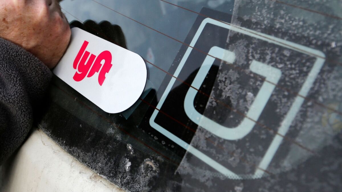Logos on a car indicate it gives rides through both Lyft and Uber.