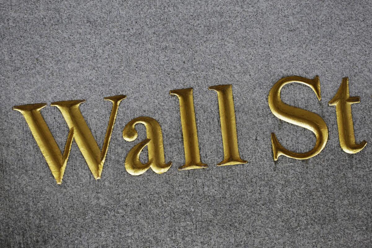 A sign for Wall Street is carved into the side of a building in New York.