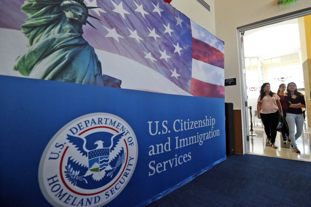 People arrive before the start of a naturalization ceremony at the U.S. Citizenship and Immigration Services  Office