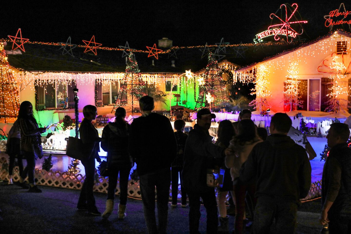 Visitors to the home of Mack Schreiber get a close look at part of the extensive Christmas light display there on Reche Road in Fallbrook.