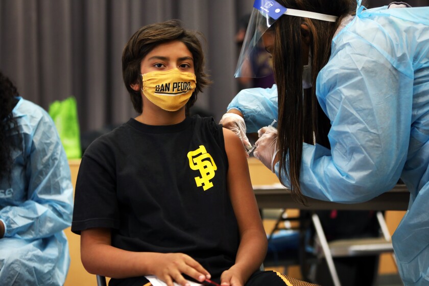 San Pedro—May 24, 2021—Alex Bugarin, age 13, gets his first vaccine at San Pedro Senior High school on Monday, May 24, 2021. San Pedro Senior High school is one of the Los Angeles County Unified schools providing coronavirus vaccines for children 12 and up. (Carolyn Cole / Los Angeles Times)
