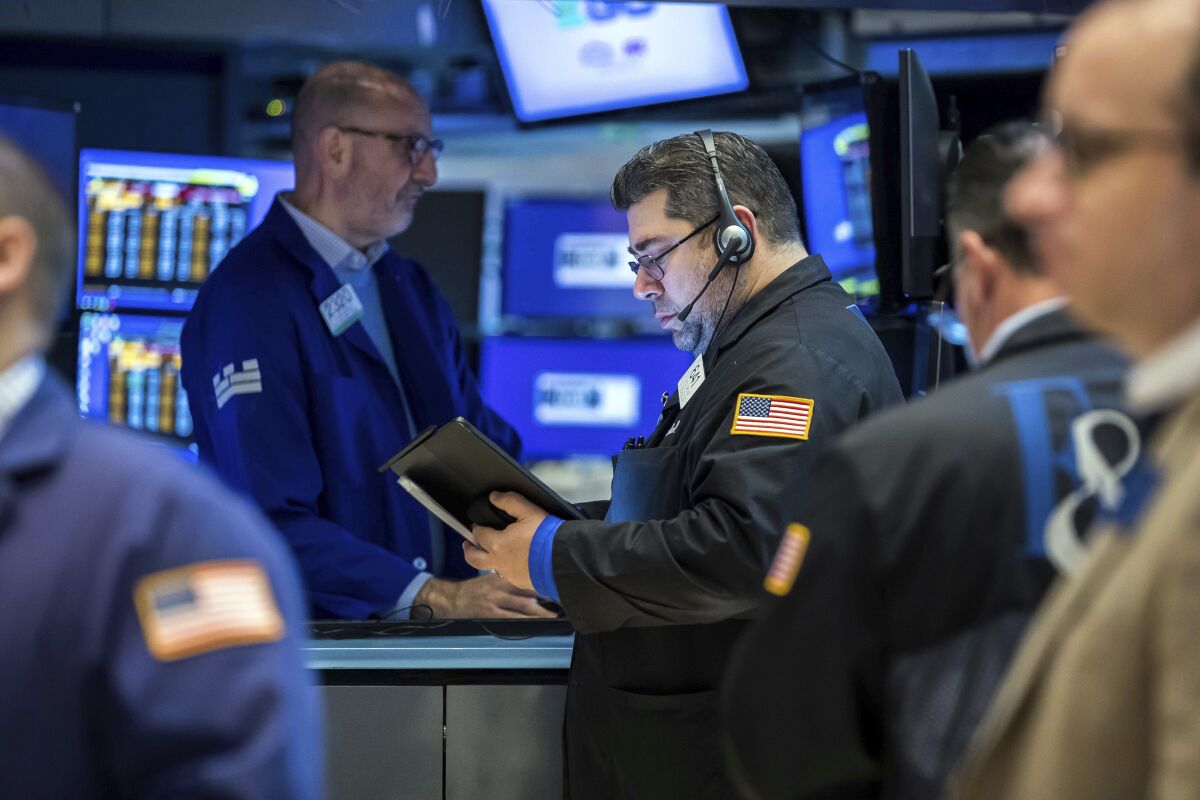 In this photo provided by the New York Stock Exchange, trader Michael Capolino, right center, works on the floor, Friday, April 8, 2022. Treasury yields continued rising as traders get accustomed to the Federal Reserve's ongoing policy pivot to fighting inflation instead of stimulating the economy. (Courtney Crow/New York Stock Exchange via AP)
