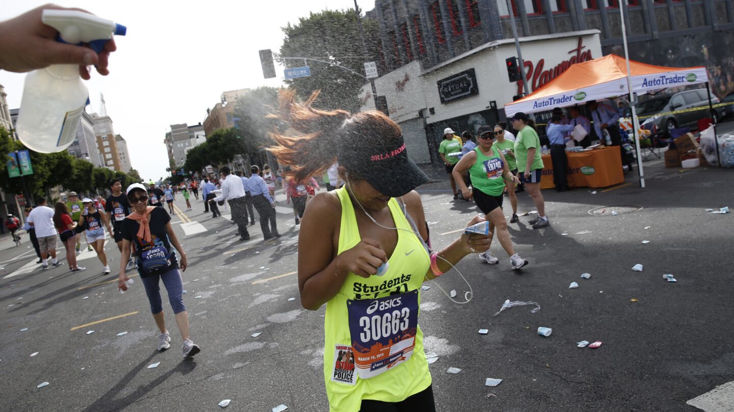 A runner gets a cooling spray on Hollywood Blvd.