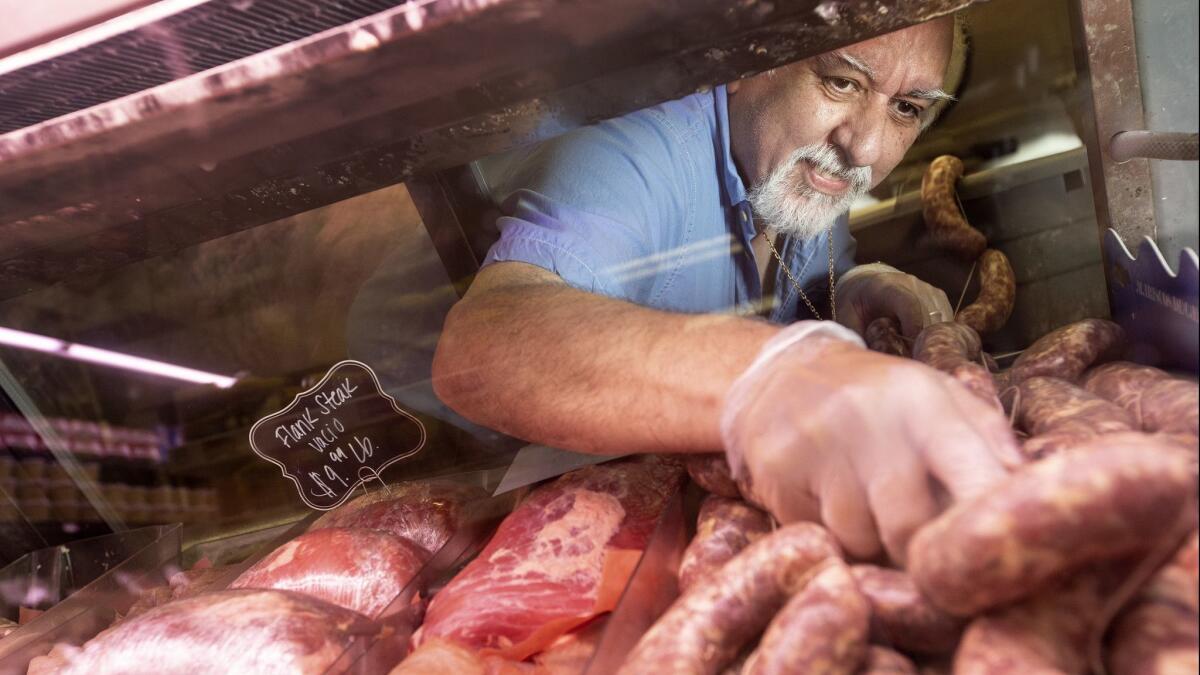 Felipe Corrado Jr. fills a display case with sausages at Catalina's Market, his family's Argentine butcher shop and grocery store in Hollywood.
