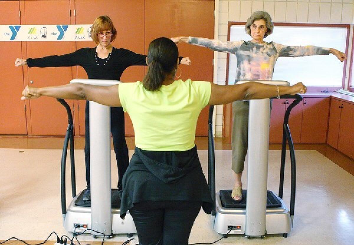 Malinda Farrington, of La Crescenta, and Bonnie Compeau, of Montrose, follow the directions of an instructor who is showing them exercises they can do on a Zaaz machine at the Crescenta-Cañada YMCA. The Zaaz exercise machine was demonstrated to a group of members on Tuesday, July 30, 2013.