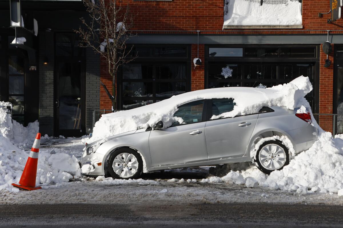 A car sits buried under snow.