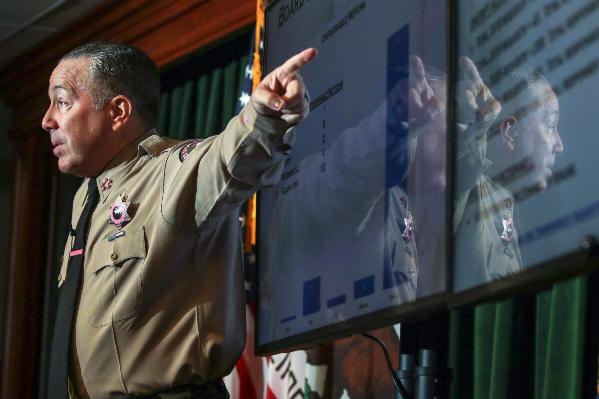 Sheriff Alex Villanueva points with his left hand while speaking.