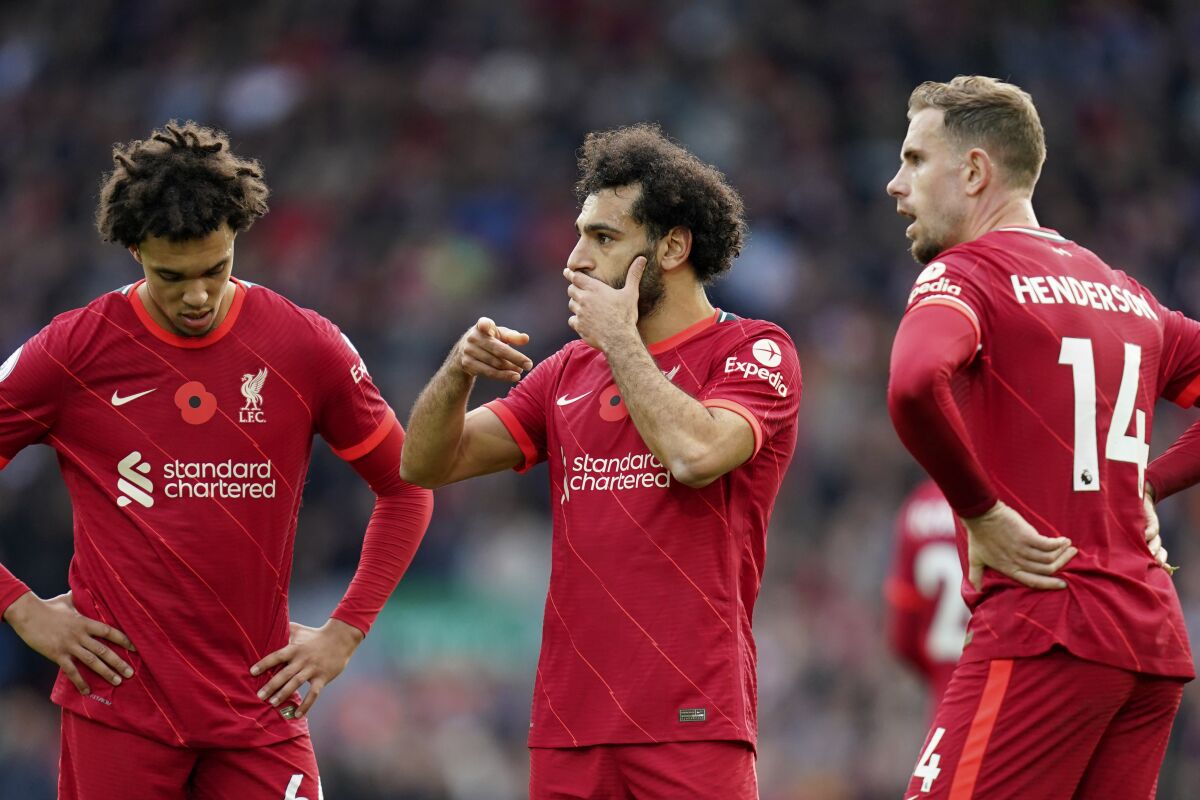 Liverpool's Trent Alexander-Arnold, Mohamed Salah and Jordan Henderson, from left to right, talk after Brighton scored their second goal during the English Premier League soccer match between Liverpool and Brighton and Hove Albion at Anfield Stadium, Liverpool, England, Saturday, Oct. 30, 2021. (AP Photo/Jon Super)
