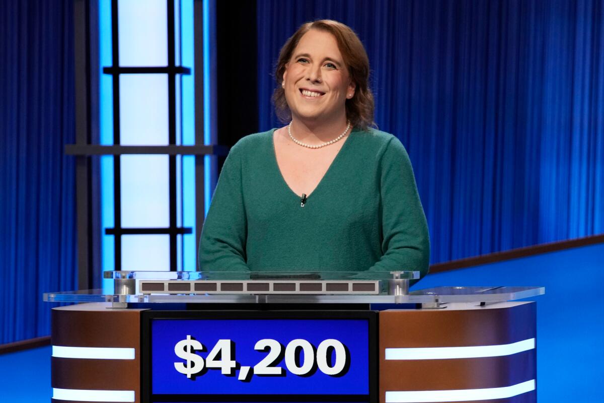 A woman in a green sweater standing behind a podium