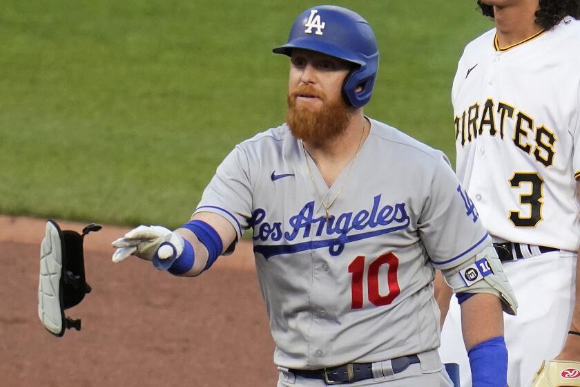 Dodgers' Justin Turner tosses his pads as he stands on second after hitting a double