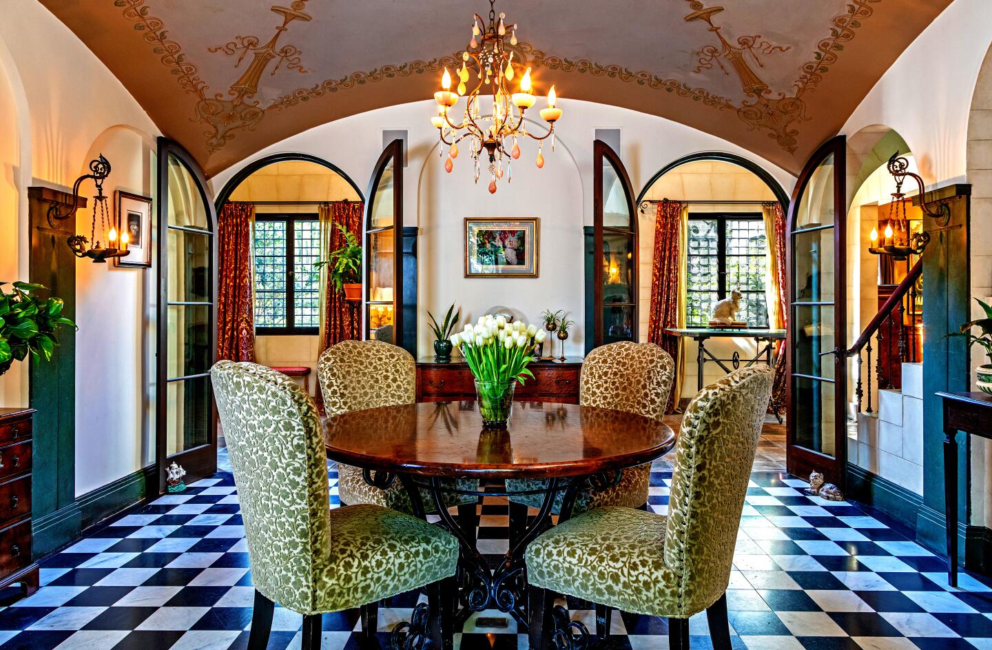 The breakfast nook with a dinette set, checkered tile, windows overlooking outdoors.