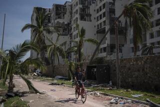 A man rides at a damaged zone in the aftermath of Hurricane Otis in Acapulco, Mexico, Sunday, Oct. 29, 2023. Mexican authorities have raised the toll to 48 dead from the Category 5 storm that struck the country's southern Pacific coast. (AP Photo/Felix Marquez)