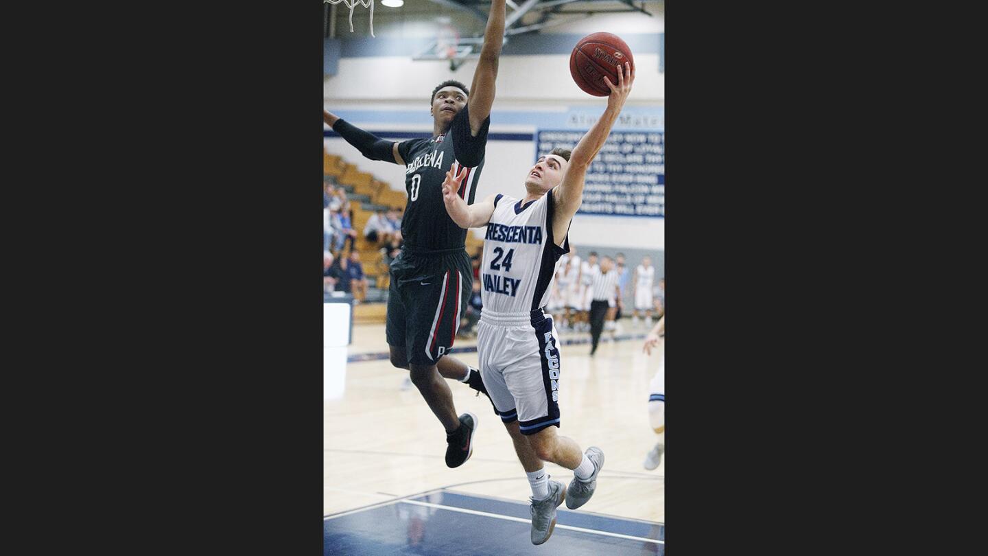 Crescenta Valley's Armen Pezeshkian eyes the basket for a layup attempt, but is blocked by Pasadena's Bryce Hamilton in a Pacific League boys' basketball game at Crescenta Valley High School on Wednesday, January 3, 2018.