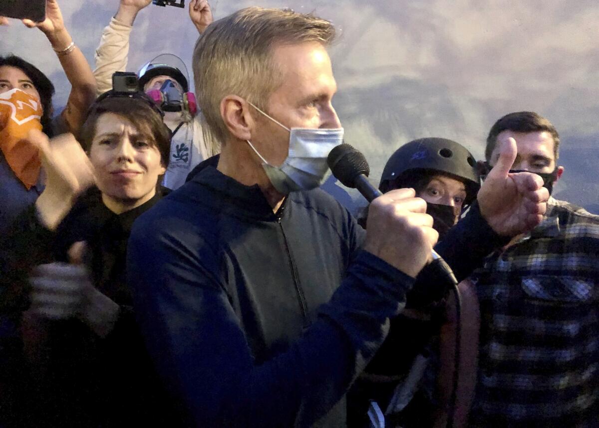 Mayor Ted Wheeler addresses a crowd in downtown Portland, Ore.