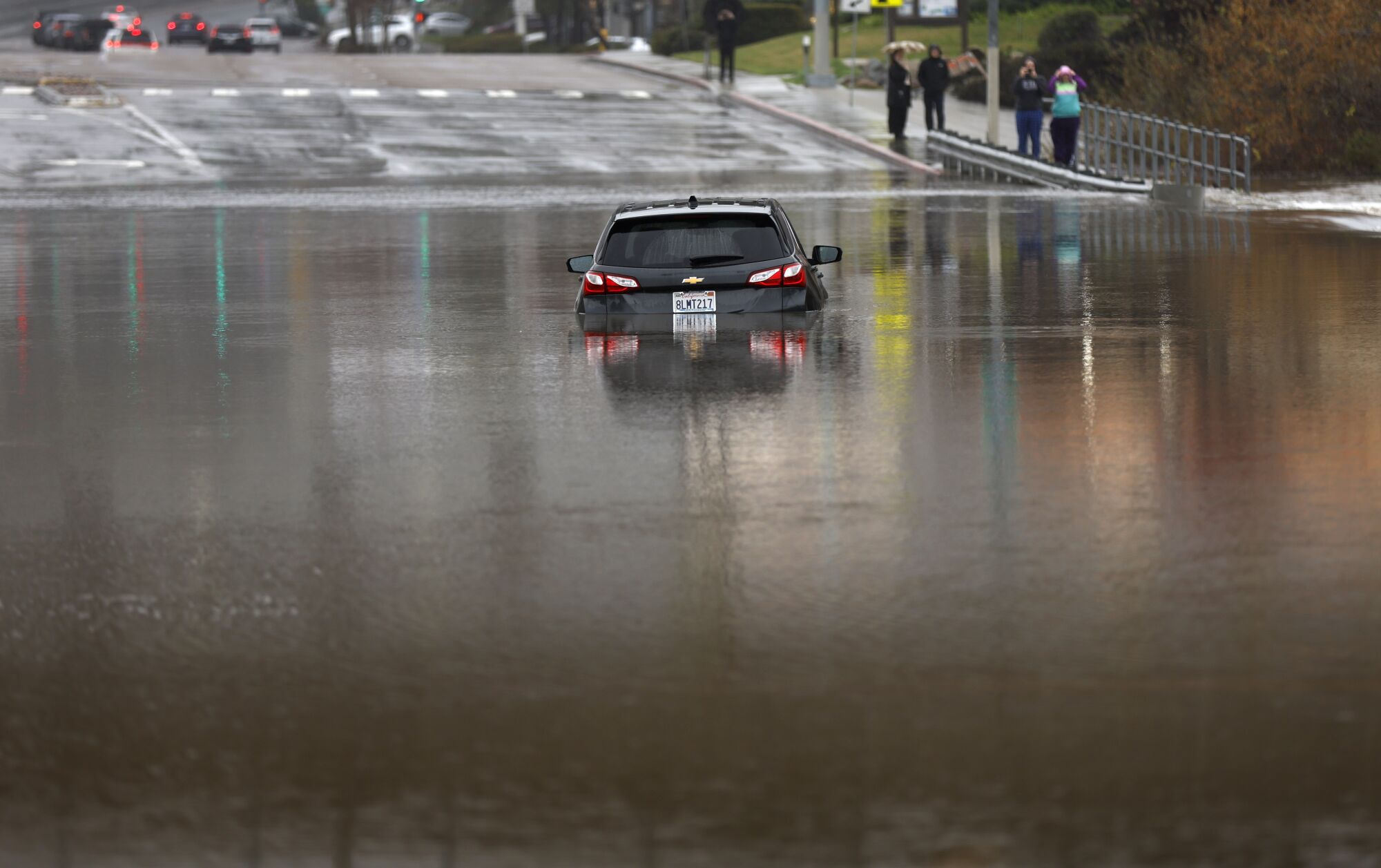 A car was submerged on a flooded Mission Center Road at the San Diego River in Mission Valley.