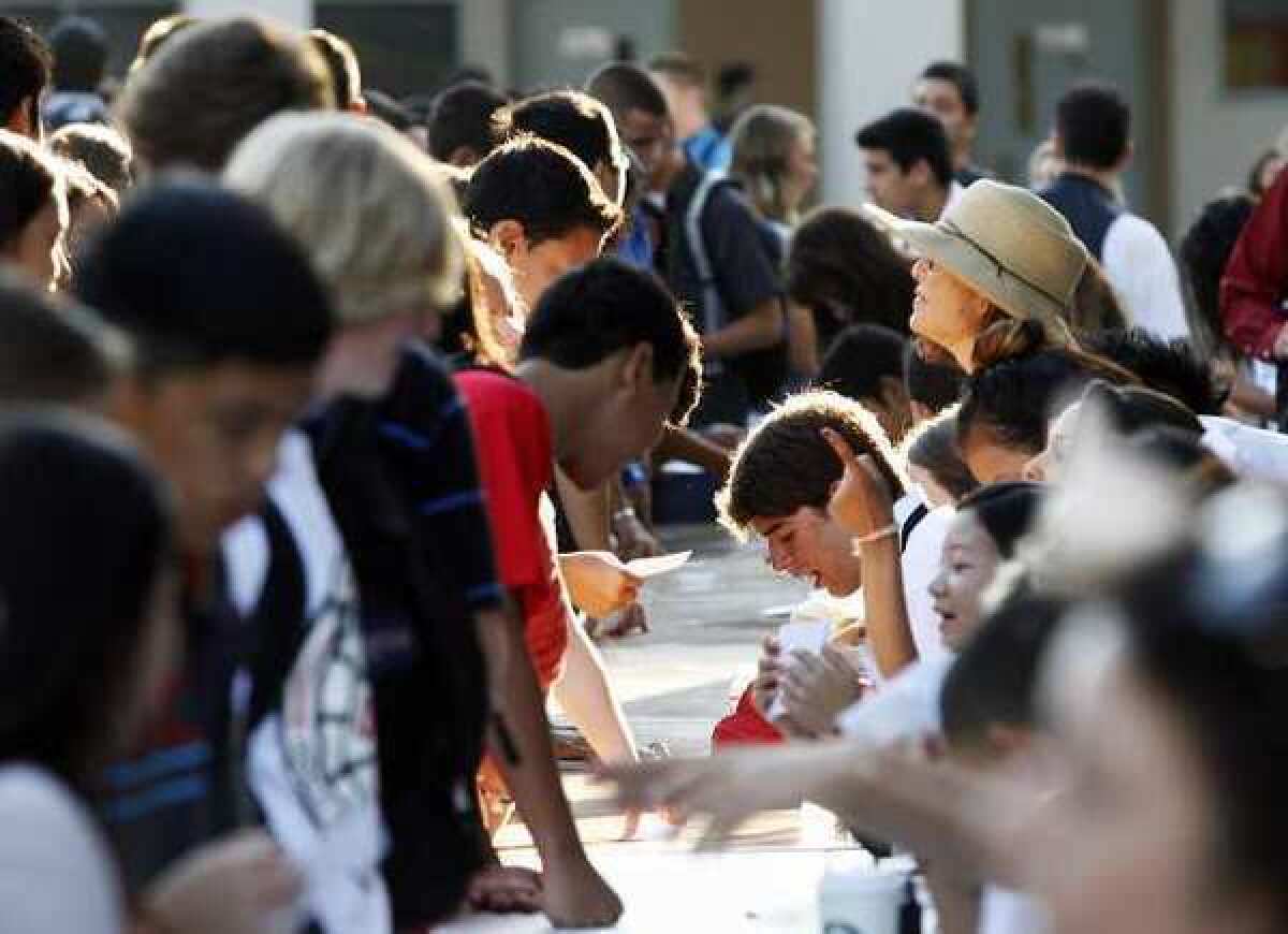 A long line of alphabetcally organized tables doled out the schedules for students on the first day of school at John Burroughs High School in Burbank on Monday, August 13, 2012.