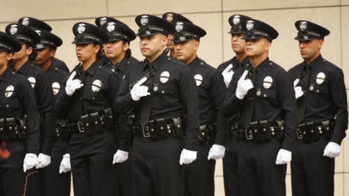 Los Angeles police cadets stand at attention during their graduation ceremony Friday morning at LAPD headquarters in downtown L.A.