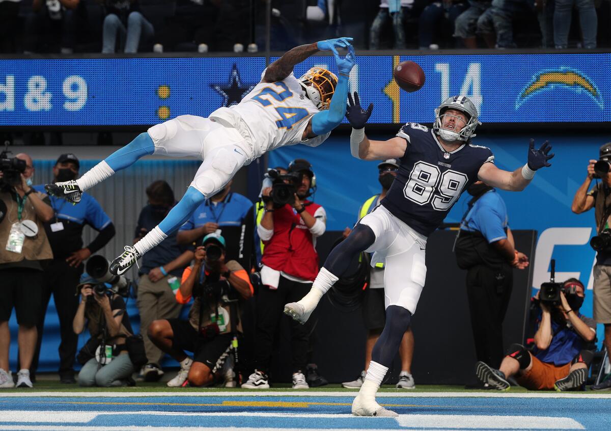 Chargers' Nasir Adderley leaps to break up a potential touchdown pass to Dallas Cowboys tight end Blake Jarwin.