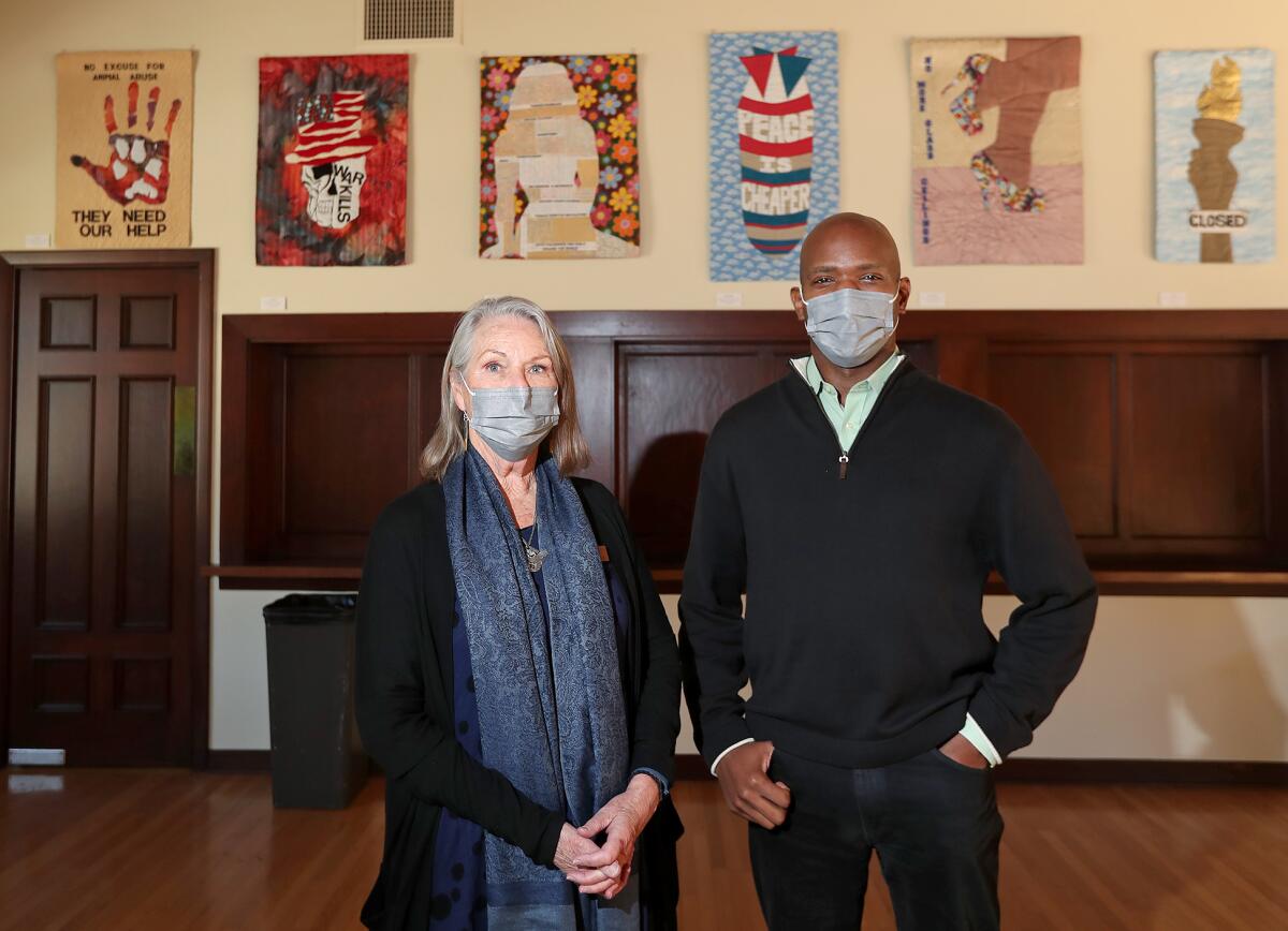 Faye Baglin and The Rev. Rodrick Echols stand with Allyson Allen's "Piece-Ful Protest" quilt works.