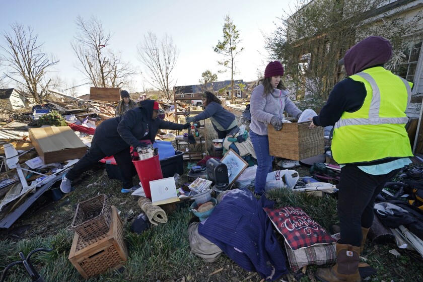 Volunteers, mostly from the Mayfield Consumer Products factory, help salvage possessions from the destroyed home of Martha Thomas, in the aftermath of tornadoes that tore through the region several days earlier, in Mayfield, Ky., Monday, Dec. 13, 2021. (AP Photo/Gerald Herbert)
