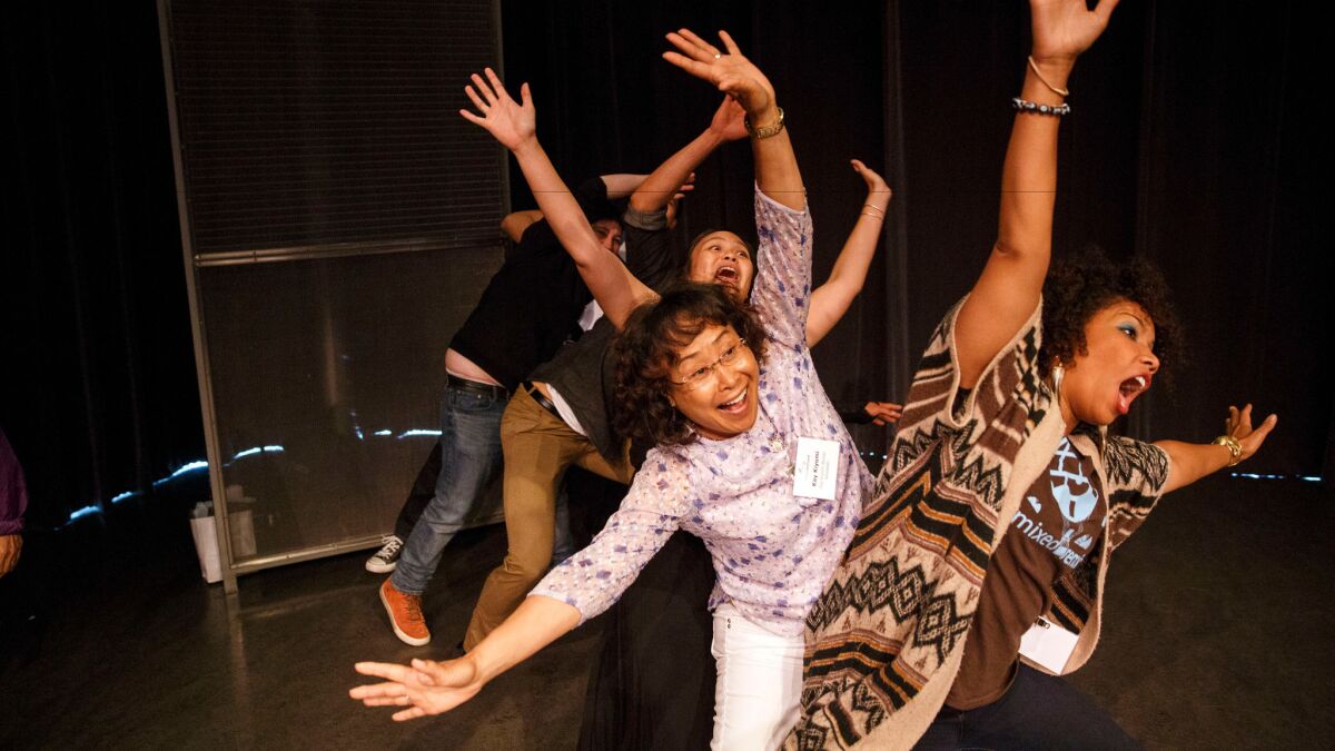 Pamela Capalad Kushner, rear left, Kay Kiyomi, center, and My-Ishia Cason-Brown, right, improv a roller coaster ride during an improv workshop during the Mixed Remixed Festival on Friday, June 10.