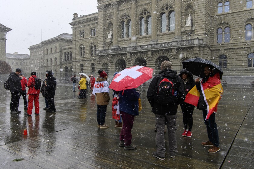 People protest during a rally of opponents of the COVID-19 law, in Bern, Switzerland, Sunday, Nov. 28, 2021. Swiss voters appear set to approve by a clear margin legislation which introduced a special COVID-19 certificate that lets only people who have been vaccinated, recovered or tested negative attend public events and gatherings. (Anthony Anex/Keystone via AP)