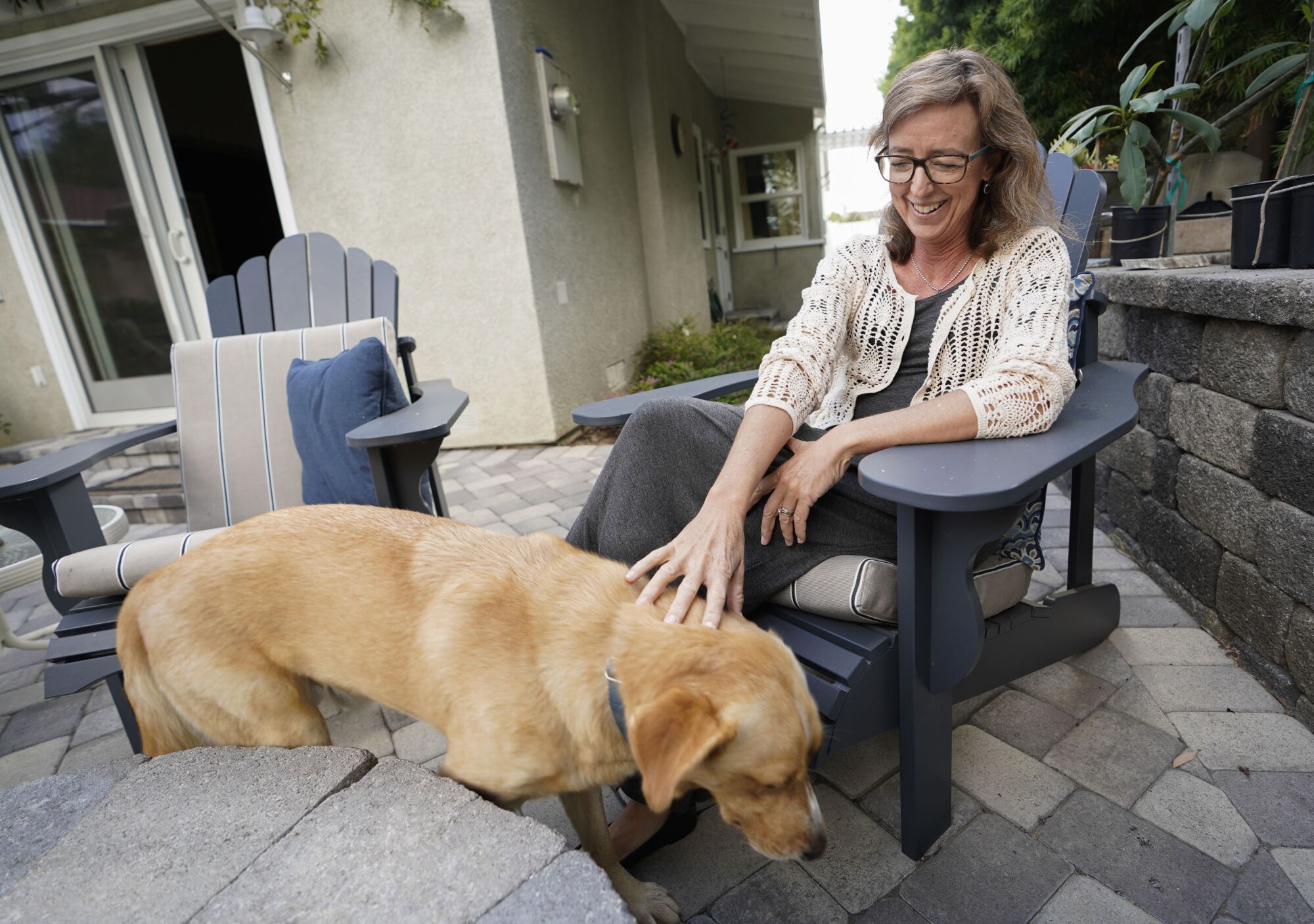 Longtime cancer patient Nancy Davidson with her dog Max in the backyard of her home in Costa Mesa on October 15, 2019.