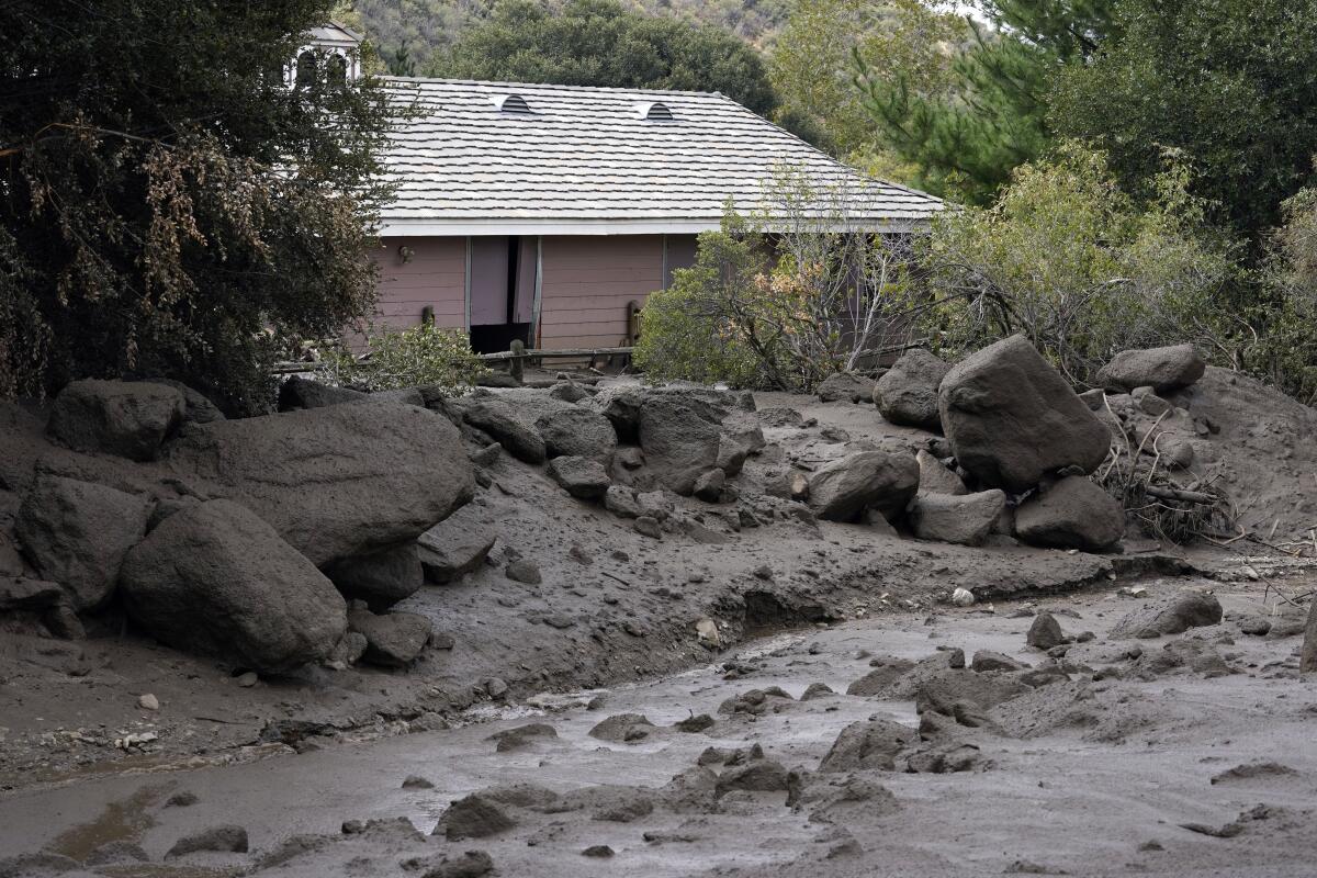 FILE - The front yard of a property is covered in mud in the aftermath of a mudslide Tuesday, Sept. 13, 2022, in Oak Glen, Calif. A woman who went missing after flash floods unleashed mudslides that swept through her town in the Southern California mountains earlier this week has been found dead under a pile of mud, rocks and other debris, authorities said Friday, Sept. 16, 2022. (AP Photo/Marcio Jose Sanchez, File)