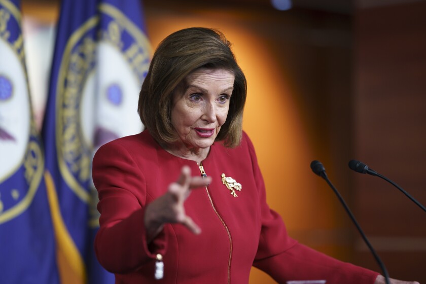 Speaker of the House Nancy Pelosi gestures while discussing President Biden's domestic agenda from behind a podium