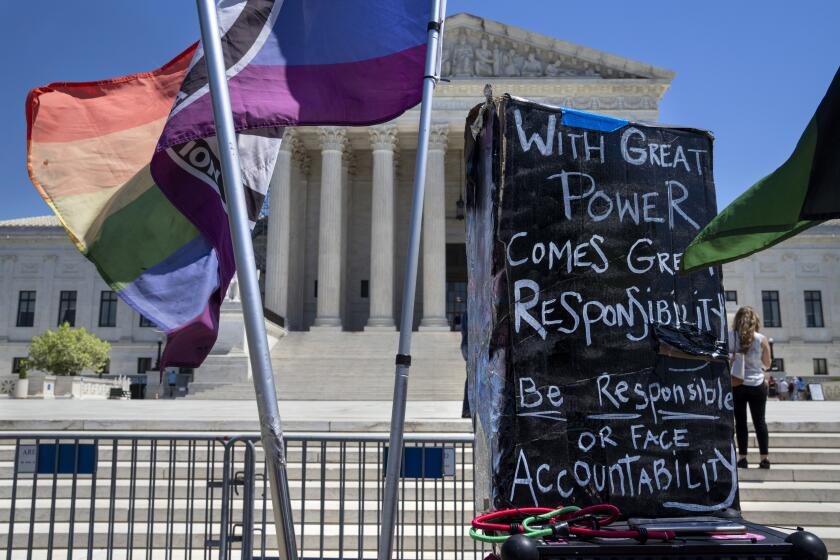 A demonstrator in favor of access to abortion pills places signage about the Supreme Court, Friday, April 21, 2023, outside the Supreme Court in Washington. (AP Photo/Jacquelyn Martin)