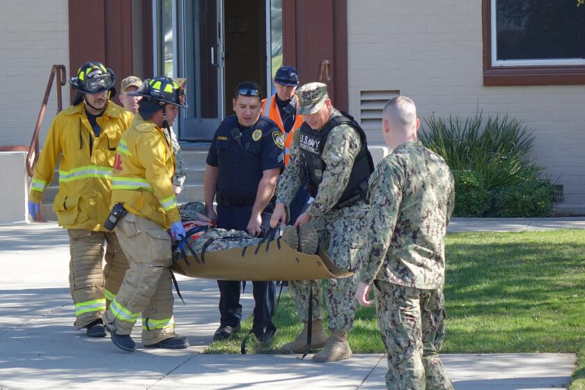 U.S. Navy Security Forces and Department of Defense firefighters carry a sailor during an active shooter drill Tuesday at Naval Weapons Station Seal Beach.