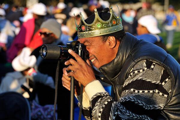 A man wearing a crown takes pictures