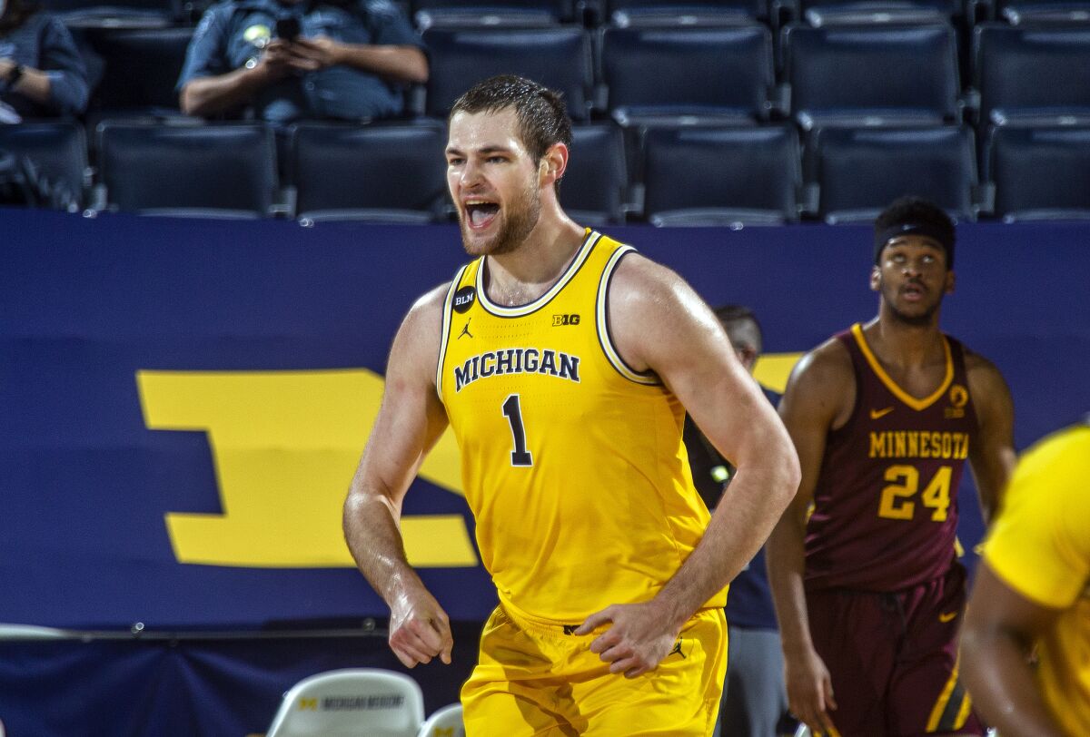 Michigan guard Franz Wagner (21) celebrates after making a dunk in the first half of an NCAA college basketball game against Minnesota at Crisler Center in Ann Arbor, Mich., Wednesday, Jan. 6, 2021. (AP Photo/Tony Ding)