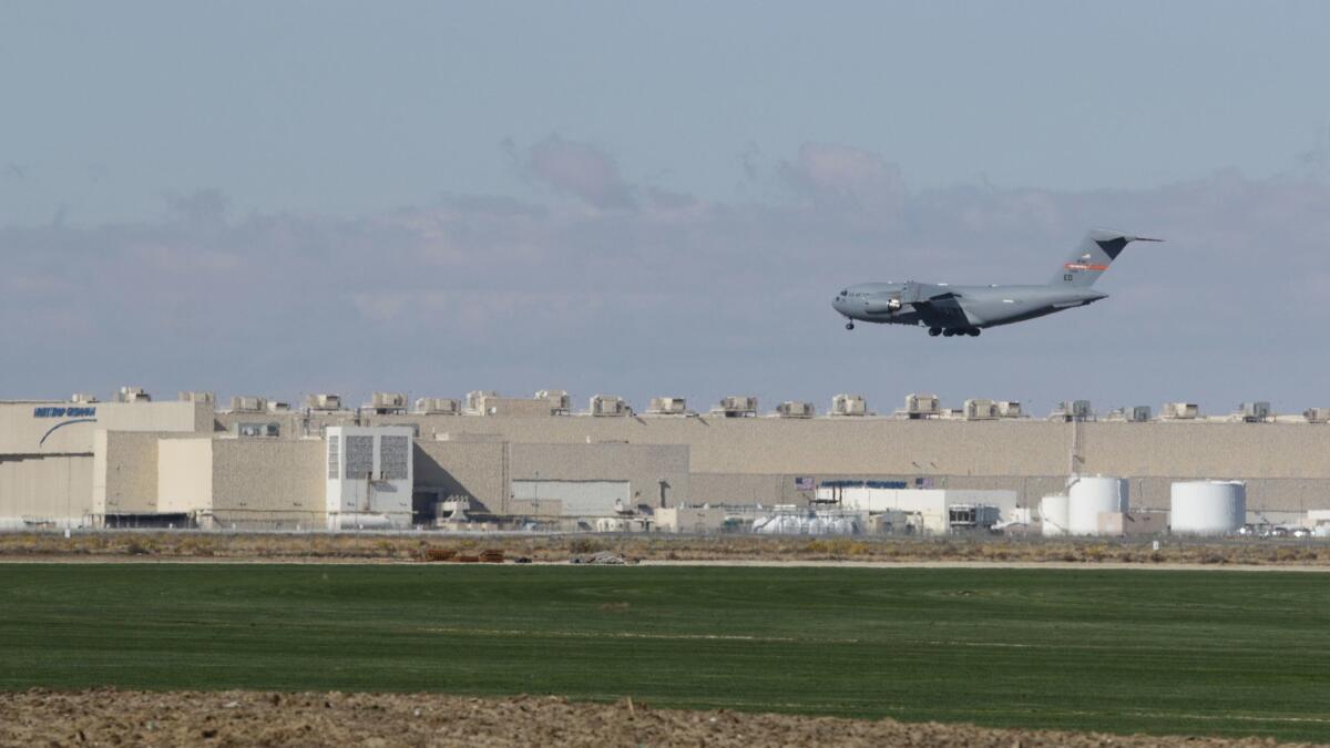 A Boeing C-17 Globemaster III flies past the Northrop Grumman aircraft plant in Palmdale. The company plans to increase employment by more than 2,000 jobs by late next year in Palmdale, where it will complete final assembly of the U.S. Air Force’s B-21 bomber.