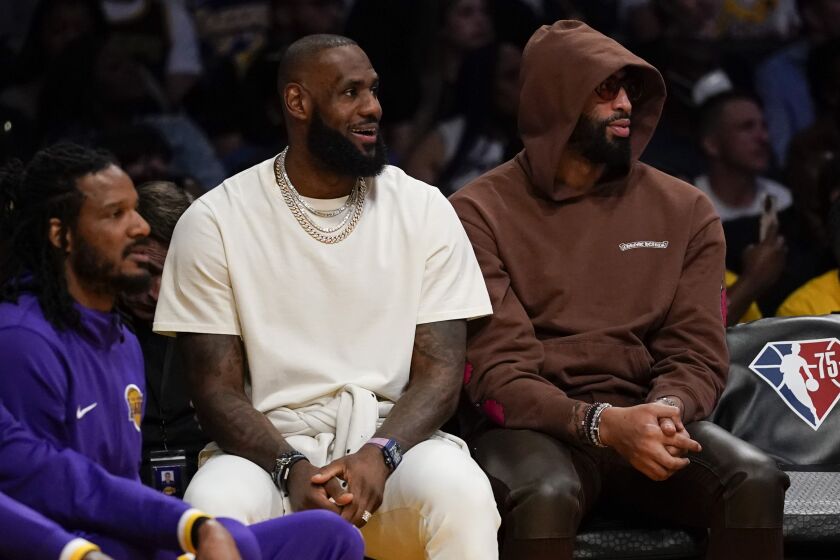 Los Angeles Lakers' LeBron James and Anthony Davis sit on the bench during an NBA basketball game against the Philadelphia 76ers in Los Angeles, Wednesday, March 23, 2022. (AP Photo/Ashley Landis)