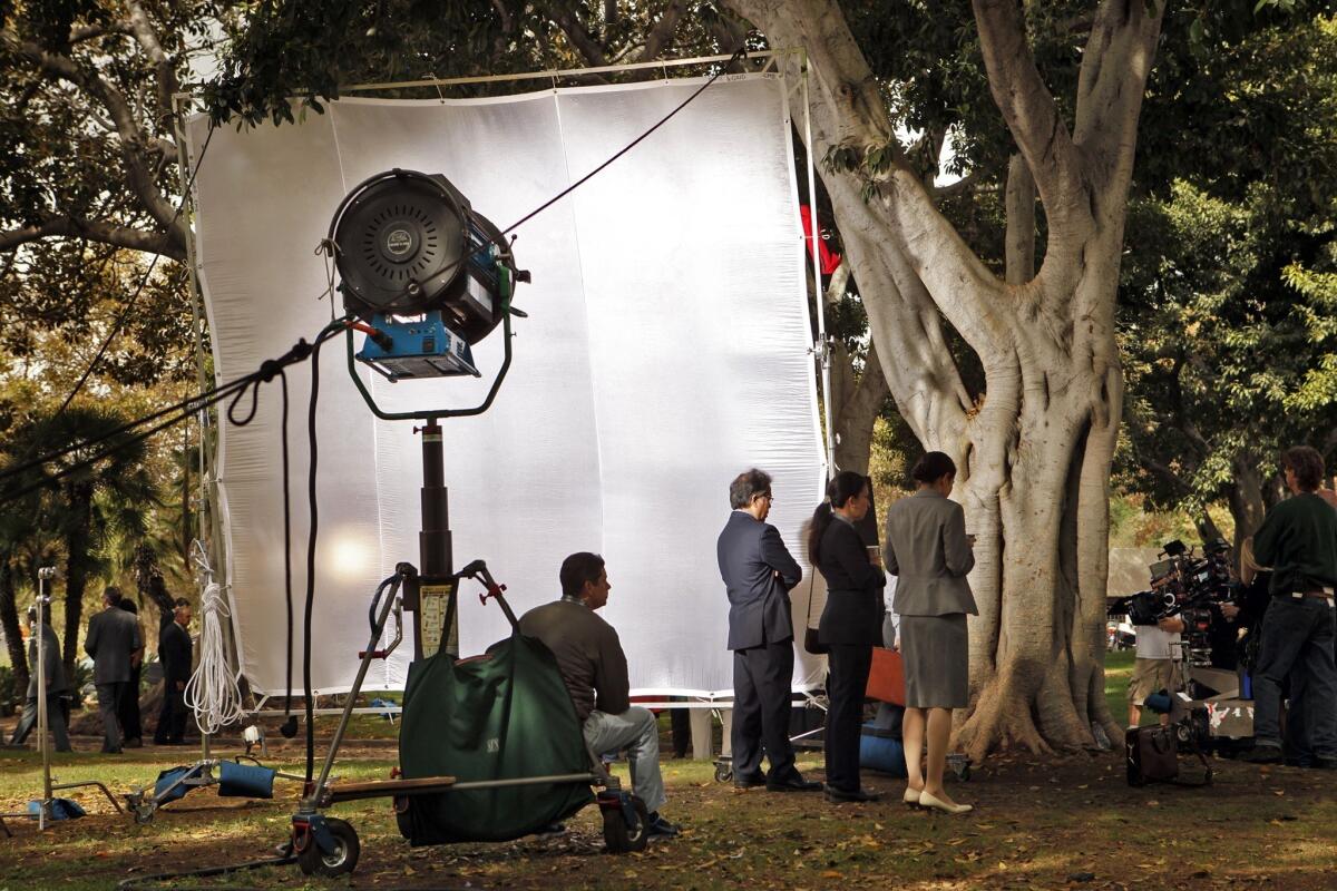 A film crew sets up lights and cameras for shooting the second episode and finishing the pilot for the television series "Franklin & Bash" on the lawn of Los Angeles City Hall.